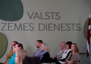 Paneļdiskusiju “Ilgtspēja. Noturība. Kompetenču esība.” klausītāji, fonā uzraksts "Valsts zemes dienests"