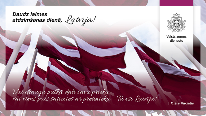 Vairāki Latvijas valsts karogi plīvo vējā uz karogmastiem pret gaišām debesīm. Attēla augšdaļā teksts “Daudz laimes atdzimšanas dienā, Latvija!”, apakšdaļā Ojāra Vācieša citāts, labajā pusē – Valsts zemes dienesta emblēma.